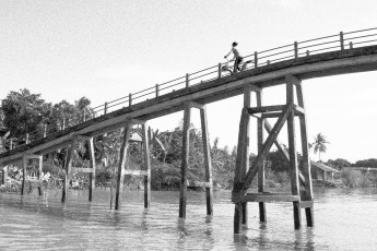 Frau auf Fahrrad auf Brücke über Kanal