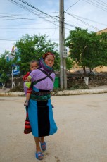 A Hmong Woman with a child on her back